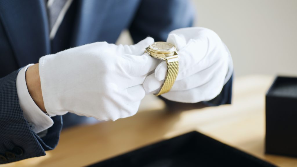 Image of a man with white gloves on evaluating a watch. Pacific Jewelry Buyers: We provide professional and trustworthy appraisals.