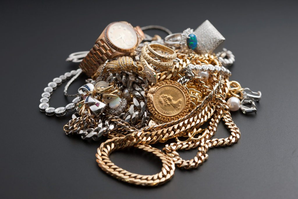 Image of a pile of jewelry against a grey background. Pacific Jewelry Buyers: we provide appraisals. We buy jewelry.